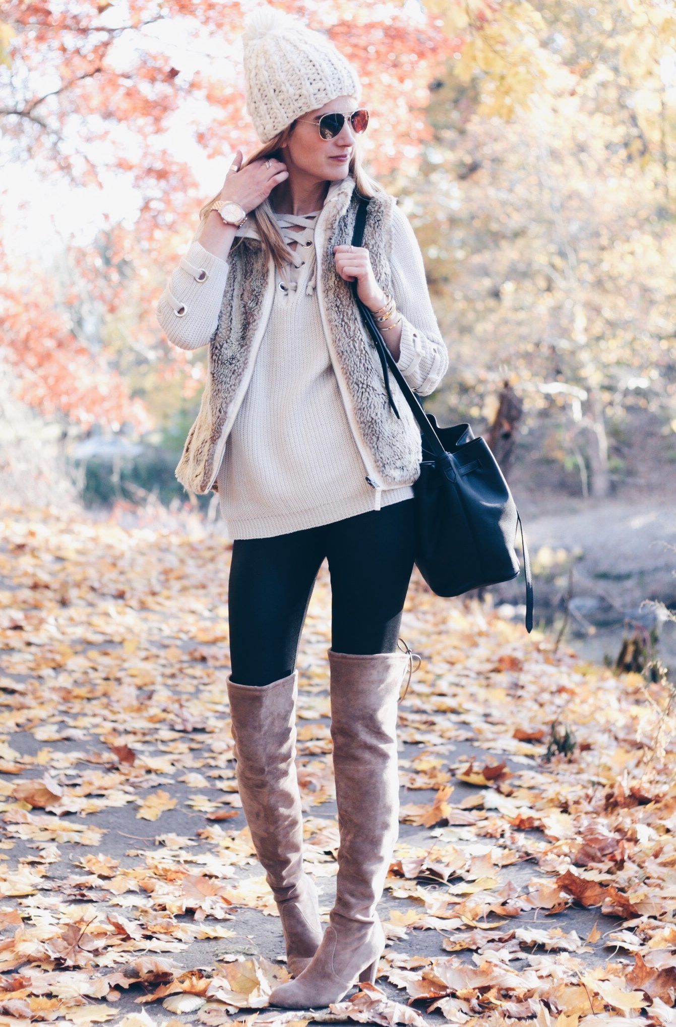 winter outfit over the knee boots and leather leggings with lace up sweater and fur vest